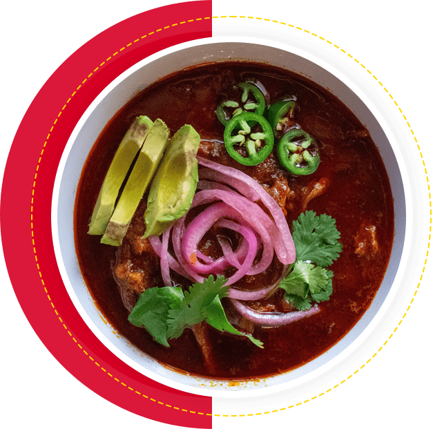 A bowl of chili with jalapenos, onions and cilantro.